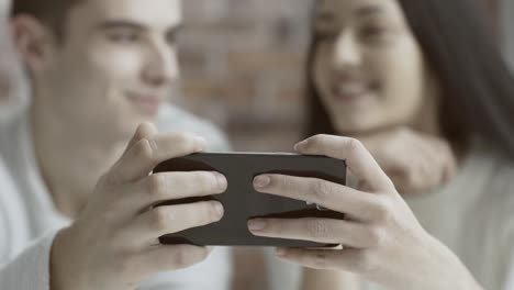 Friends-watching-a-video-together-on-a-smartphone