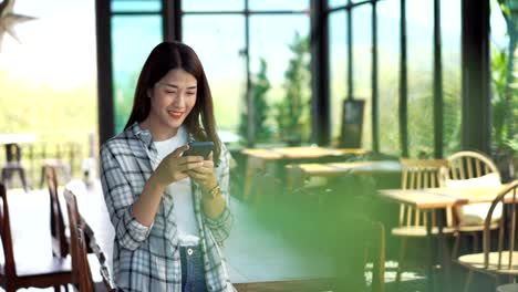 mujer-feliz-usando-un-smartphone-en-un-café