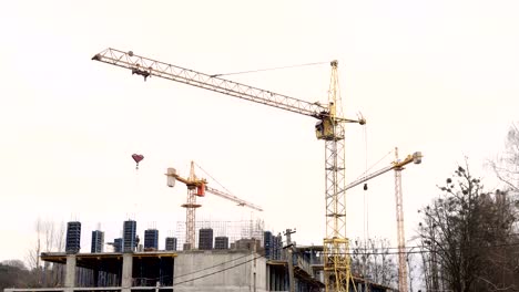 Timelapse-Bauindustrie.-Drei-Kräne-und-eine-Gruppe-von-Arbeitern-bauen-ein-Haus.