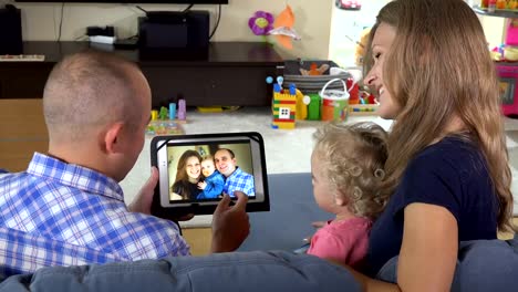 mujer-hombre-y-niña-pequeña-viendo-fotos-de-la-familia-en-la-tableta-PC-en-casa