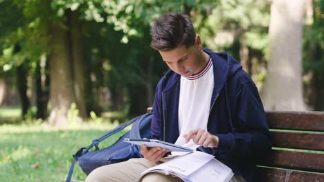 A-student-sitting-on-a-bench-uses-the-phone-to-send-messages,-and-surf-on-social-networks-and-stay-in-touch-with-their-friends.