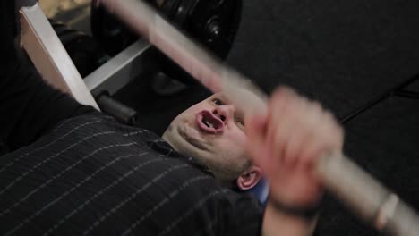 Cheerful-fat-man-performs-the-wrong-bench-press-in-the-gym