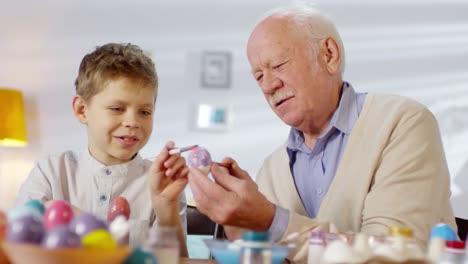 Abuelo-y-nieto-pintando-huevo-juntos