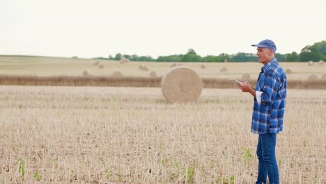 Moderne-Landwirtschaft.-Die-Liebe-zur-Landwirtschaft.-Landwirt-mit-digitalem-Tablet-bei-der-Prüfung-von-Bauernhof