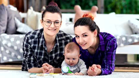 Zwei-hübsche,-lässige-lächelnde-Frau-und-ein-kleines-niedliches-Kind-posieren-mit-Blick-auf-die-Kamera