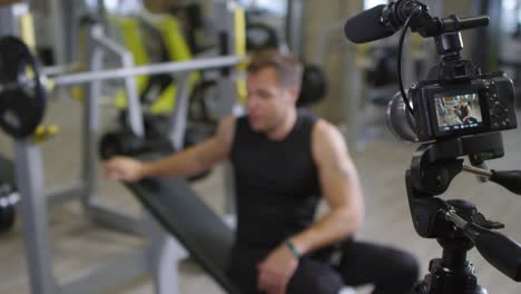 Gym-Coach-Explaining-Barbell-Exercise-on-Camera