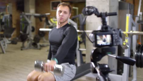 Athletic-Man-Exercising-with-Dumbbells-on-Camera