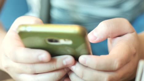 Boy-hands-using-smartphone-in-cafe.