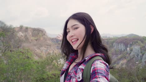 Blogger-Asian-backpacker-woman-record-vlog-video-on-top-of-mountain,-young-female-happy-using-mobile-phone-make-vlog-video-enjoy-holidays-on-hiking-adventure.-Lifestyle-women-travel-and-relax-concept.