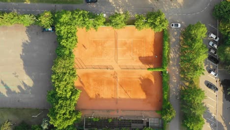 Blick-von-oben-nach-unten-auf-den-öffentlichen-Stadtpark-und-die-Tennisplätze