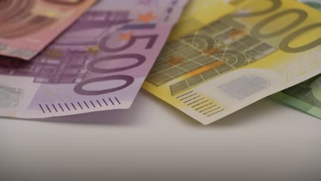 4K-Closeup-einer-Münze-einen-Euro-mit-Banknoten-mit-unterschiedlichen-Werten.-Bargeld