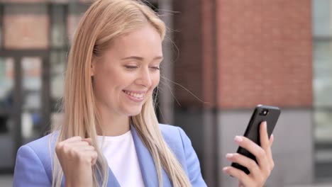 Young-Businesswoman-Celebrating-Win-on-Smartphone