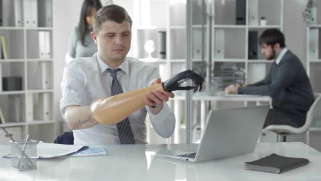 Businessman-Typing-on-Laptop-and-Putting-On-Prosthetic-Hand