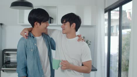 Asian-gay-couple-drinking-coffee,-having-a-great-time-at-home.-Young-handsome-LGBTQ+-men-talking-happy-relax-rest-together-spend-romantic-time-in-modern-kitchen-at-house-in-the-morning-concept.