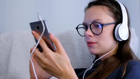 Frau-ist-surfen-und-suchen-in-sozialen-Medien-in-Smartphone-in-Brille-und-Kopfhörer.