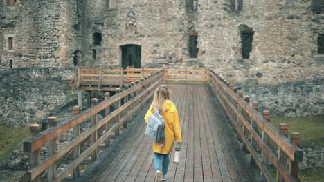 A-lady-with-a-lantern-is-walking-along-a-wooden-bridge