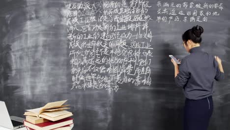 Junge-asiatische-Lehrer-Schreiben-Hieroglyphen-auf-Blackboard