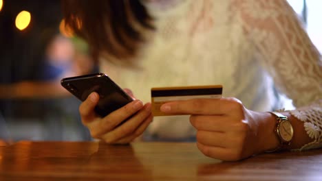 Joven-mujer-asiática-comprando-en-el-teléfono-móvil-con-pago-con-tarjeta-de-crédito