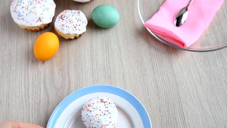 Die-Hände-sind-auf-dem-Tisch-Ein-Teller-mit-weißen-Ostern-Kuchen-mit-Zuckerguss.