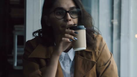 Woman-drinking-coffee-at-the-window