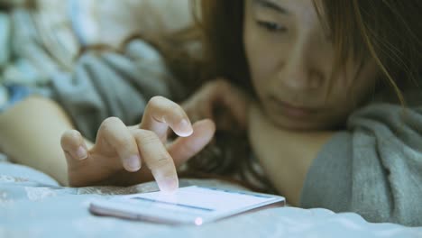 Woman-using-cellphone-in-bed-at-night