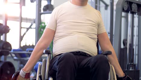 Hombre-con-discapacidad-en-silla-de-ruedas-ejercitarse-con-pesas-en-un-gimnasio.