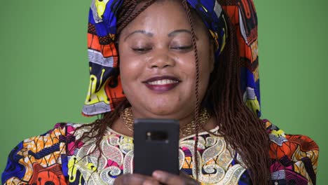 Overweight-beautiful-African-woman-wearing-traditional-clothing-against-green-background