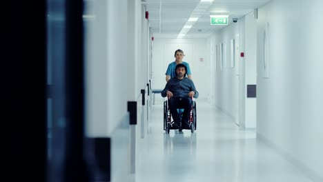 Weibliche-Krankenschwester-Pushing-Patient-im-Rollstuhl-durch-den-Krankenhausflur,-gehen-sie-zu-den-Verfahren.-Helle-moderne-Krankenhaus-mit-freundlichem-Personal.