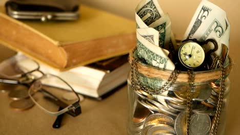 Books-with-glass-penny-jar-filled-with-coins-and-banknotes.-Tuition-or-education-financing-concept.-Scholarship-money.