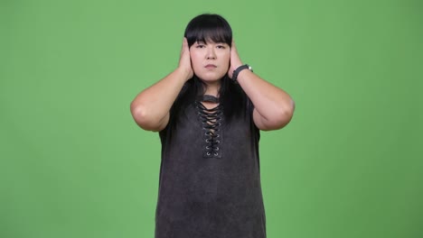 Beautiful-overweight-Asian-woman-covering-ears-as-three-wise-monkeys-concept