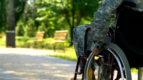 War-veteran-in-wheelchair-slowly-moving-along-park,-hero-country-defender