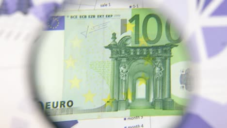 Study-of-a-banknote-one-hundred-euro,-increasing-with-the-help-of-a-magnifying-glass.