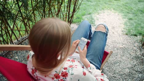 Junge-Frau-mit-Smartphone-in-Anlage-Pavillon