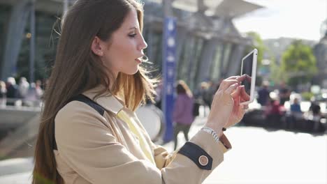 Good-looking-young-female-working-on-digital-tablet-in-public-space-outside