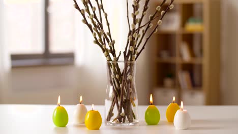 willow-and-candles-in-shape-of-easter-eggs-at-home