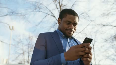 African-Businessman-with-Smartphone-Outdoors