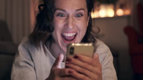 Excited-woman-using-mobile-phone-at-night