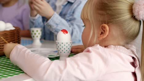 Primer-plano-de-niña-pintura-huevo-de-Pascua