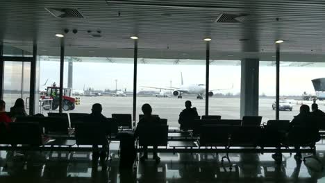 Passengers-at-the-airport-waiting-for-boarding.-Passengers-awaiting-landing-at-the-airport.-In-the-background-is-a-plane.