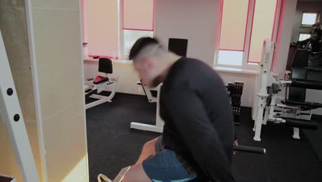 Cheerful-fat-man-performs-a-wrong-exercise-in-the-gym.-For-the-first-time-in-a-fitness-club