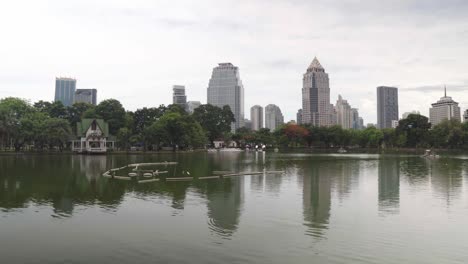 Horizonte-urbano,-edificios-del-centro-reflejados-en-el-agua.-Gran-parque-verde-con-un-lago-en-el-fondo-de-rascacielos-de-gran-altura-en-metrópolis