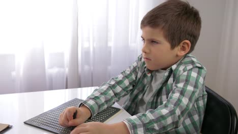 Educación-de-los-niños-con-discapacidades-visuales,-niño-ciego-aprendiendo-a-escribir-símbolos-fuente-Braille-sentado-a-la-mesa-en-brillante