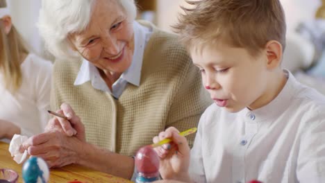 Loving-Grandmother-and-Grandson-Painting-Eggs