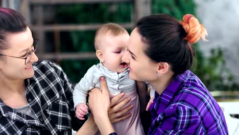 Two-hipster-informal-careful-mother-feeling-love-kissing-and-hugging-little-son-medium-close-up