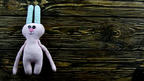 Toy-plush-hare-on-a-wooden-background