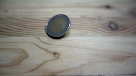 Cámara-lenta-de-rotación-de-monedas-euro-en-una-mesa-de-madera.