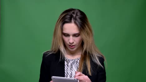 Closeup-shoot-of-young-attractive-hipster-caucasian-female-texting-on-the-tablet-with-background-isolated-on-green