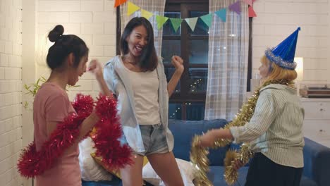 Grupo-de-mujeres-asiáticas-fiesta-en-casa,-bailar-femenino-cantando-y-escuchando-música-teniendo-divertidas-juntas-en-la-sala-de-estar-en-la-noche.-Adolescente-joven-amigo-jugar-juego,-celebrar-el-concepto-de-vacaciones.-A-cámara-lenta.