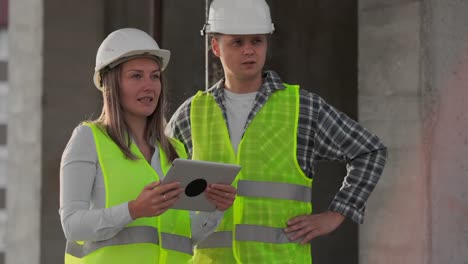 Engineers-or-architects-have-a-discussion-at-construction-site-looking-through-the-plan-of-construction.-contre-jour.-Engineers-or-architects-have-a-discussion.