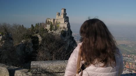 Woman-is-admiring-Guaita-tower-on-mount-Monte-Titano-in-San-Marino